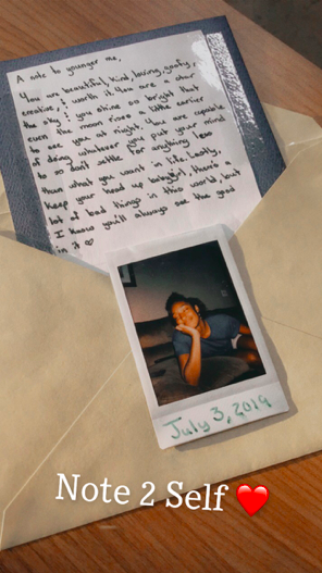 A small Polaroid sitting on an envelope. In the envelope is a note. 